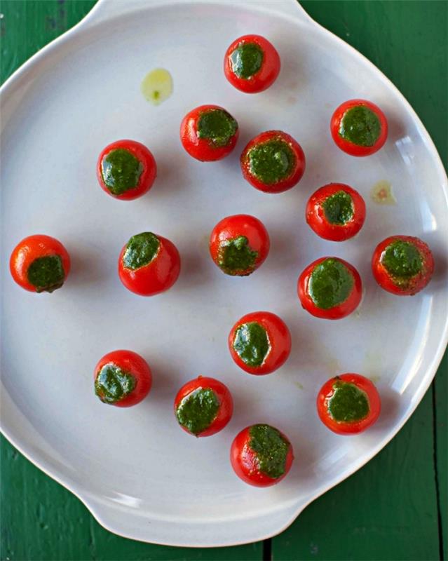 koktajl paradižnik, polnjen s kremnim sirom, okrašen z domačo pesto omako, ideje za aperitiv za 20 ljudi