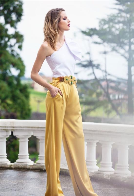 kako se ujema z barvami njenih oblačil, model hlač s širokimi nogami z zlatim pasom, okrašenim z zelenimi kamni