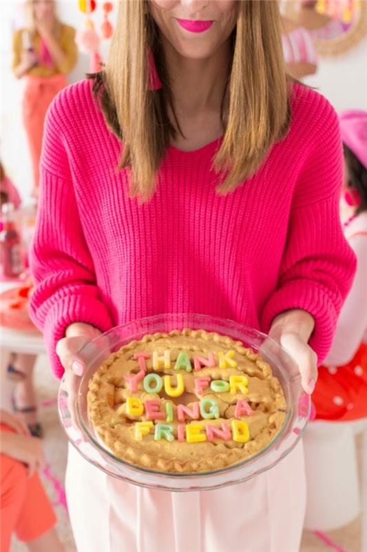 Regalo per un'amica, torta con scritta, donna con maglione rosa