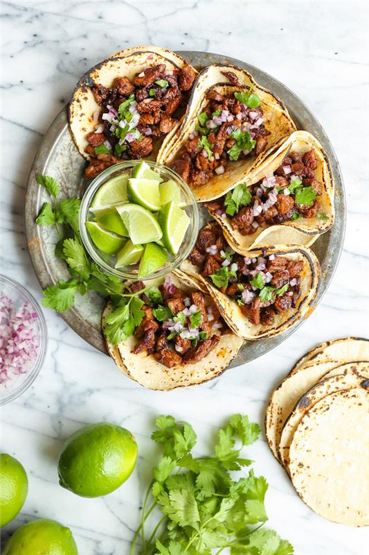 penki taco, tortilijos įvyniojimai, užpildyti jautiena, kaip pasigaminti taco mėsos, sudėti ant sidabrinės lėkštės, kalkių griežinėliai, stikliniame dubenyje