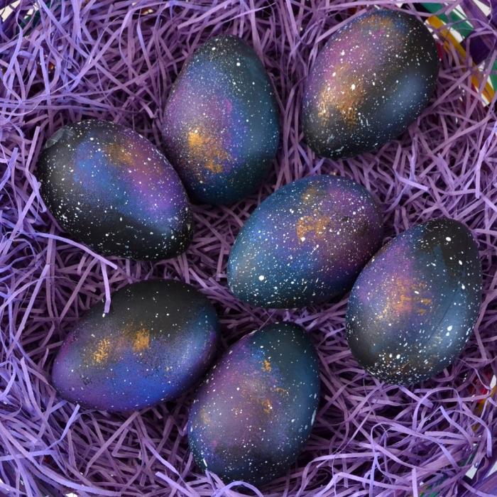 idėja originaliai Velykų dekoracijai su galaktikos efektu su juodais ir violetiniais dažais, tamsių Velykų kiaušinių lankeliu