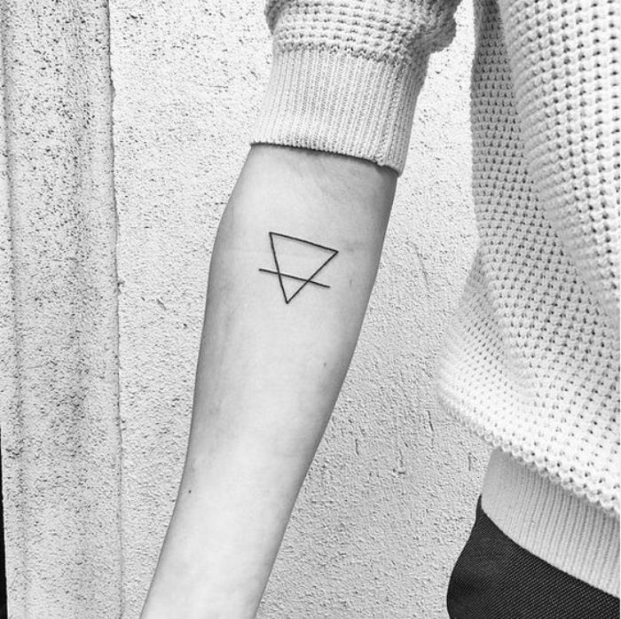 mažos tatuiruotės idėjos moterims, maža trikampio dilbio tatuiruotė, žmogus dėvi baltą megztinį
