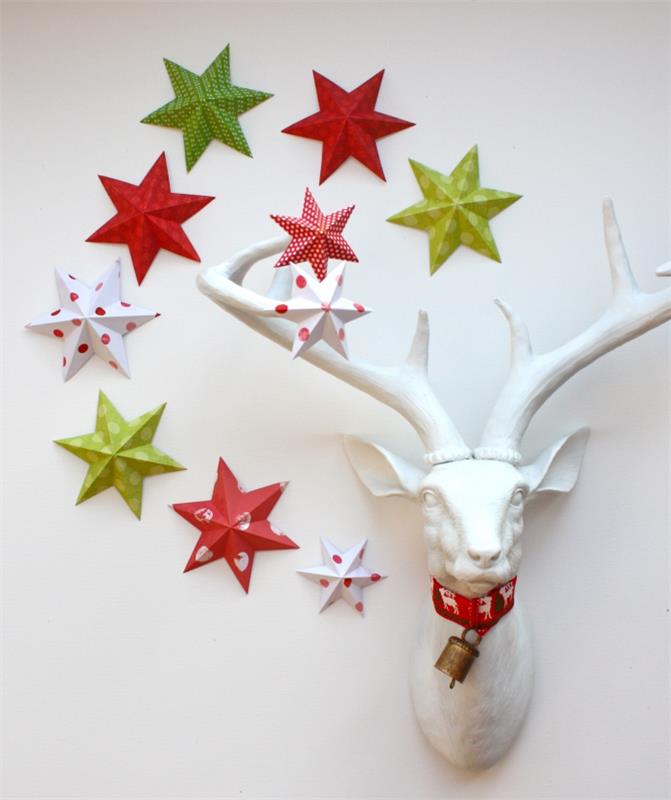 Beyaz bir geyik kupasının etrafındaki duvara bağlı 3d origami kağıt yıldızlar, ev Noel dekorasyonu