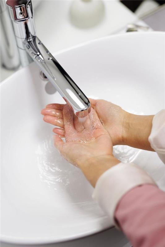 Dezinfettante per le mani fatto in casa, donna che si lava le mani sotto l'acqua con sapone