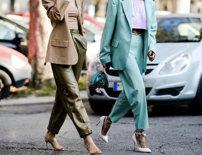 trendi oblačil 2019, dve ženski hodita po ulici, ena v zelenih usnjenih hlačah, turkizna obleka z belimi petami