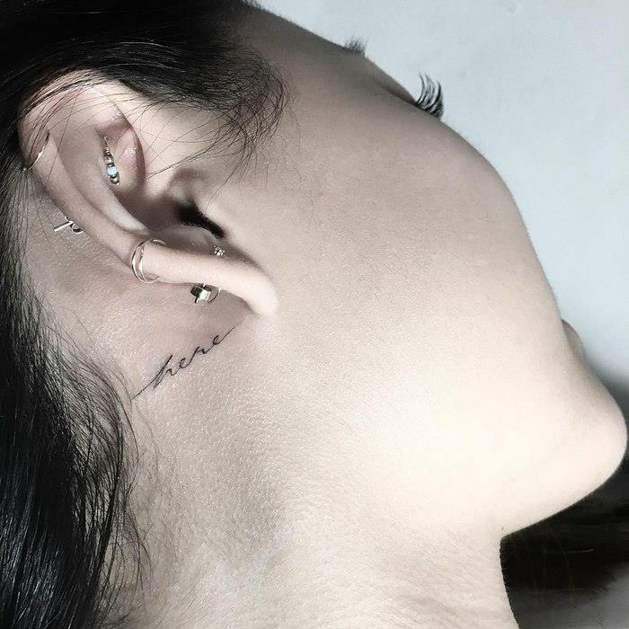 Grafični slog tetovaže pod ušesom, tukaj tipografska tetovaža, izvirna tetovaža za pisanje ozadja, kako se tetovirati, da bi prizorišče interpretirali