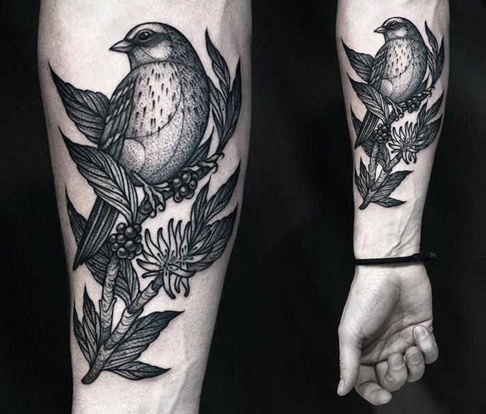 Il braccio di un uomo con il disegno di un uccello su rami con foglie