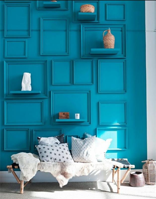 Lesena klop v skandinavskem slogu, krznena odeja, blazine v črni, beli in sivi barvi, modra stena, okrašena z modrimi okvirji, kako obleči steno
