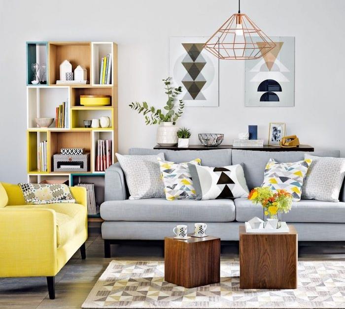 açık gri boya ile süslenmiş duvar, gri kanepe, sarı koltuk, ahşap küp sehpalar, ahşap depolama rafı, orijinal sarkıt lamba