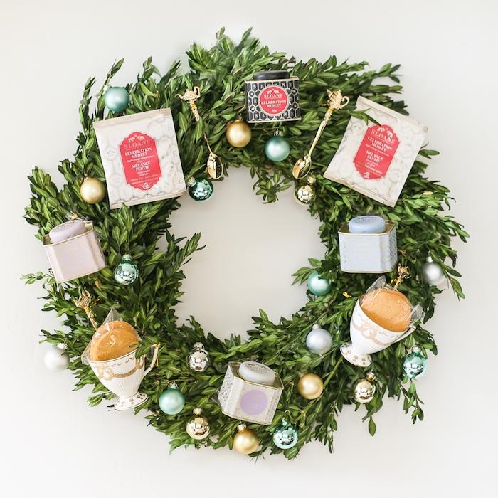 Yeşil şimşir dallarından, çay poşetlerinden ve kutularından ve küçük Noel toplarından, altın kaşıklardan yapılmış Noel çelengi