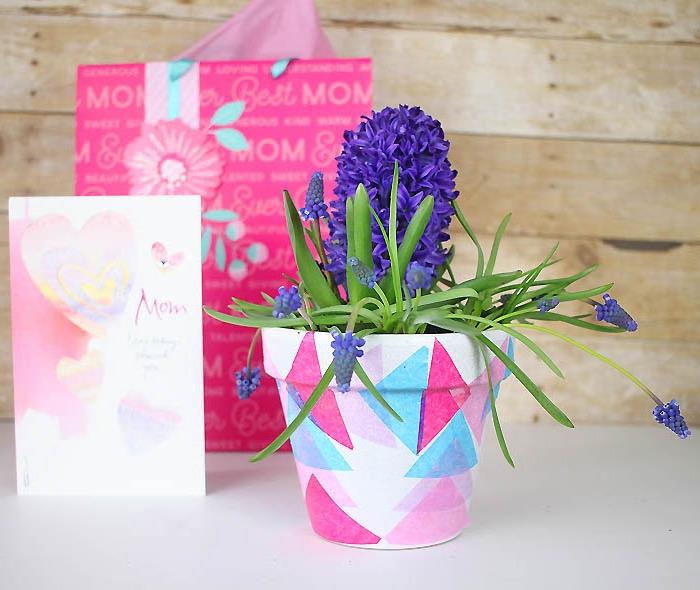 baltas gėlių vazonas, pritaikytas spalvotiems popieriniams trikampiams mėlynos, rožinės ir fuksijos, pakalnutės, dovanų idėja mamų dienai pasigaminti patiems