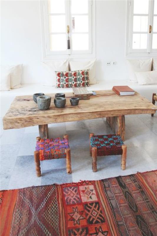 gyvenamasis kambarys graikiško stiliaus su gražiu stalu, esančiu puode, medžio ir spalvos alinea kilimu