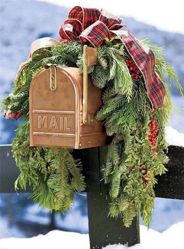 çam dalları ve kare bir kurdele ile Noel için dekore edilmiş bir mektup kutusu