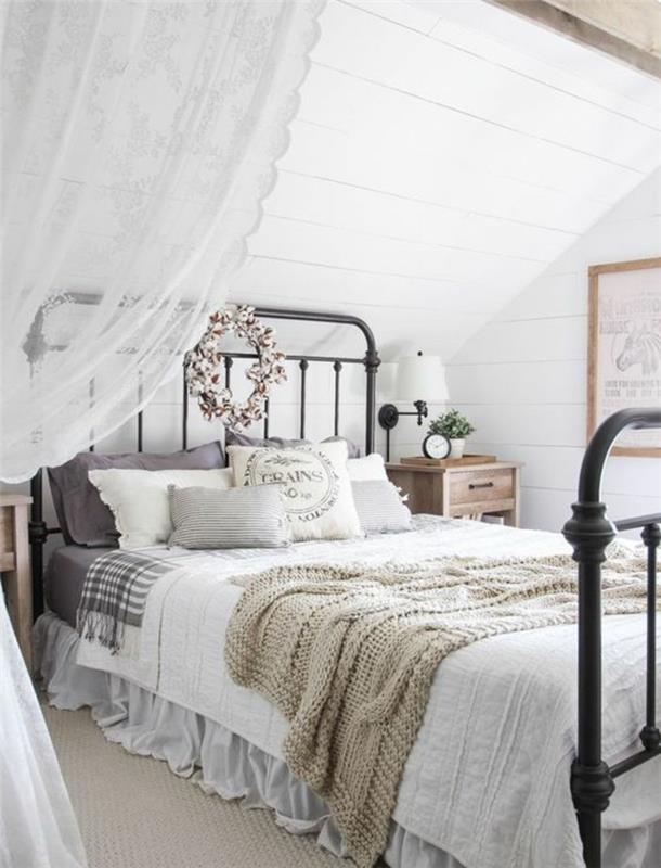 spalnica za odrasle pod pobočjem, kovinska postelja, belo in sivo posteljnina, bele obloge, krona iz tkanine, bela zavesa, eleganten deželni dekor
