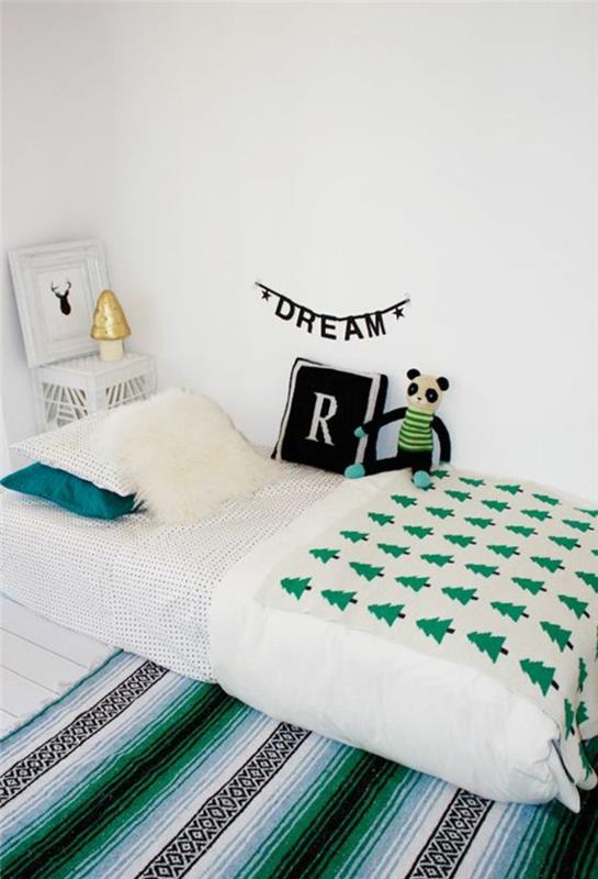 preproga v smaragdno zeleni in črni barvi, postelja montessori, spalnica montessori, jaslice brez palic, postelja iz koče montessori, napis s črnimi črkami na beli steni Rêve