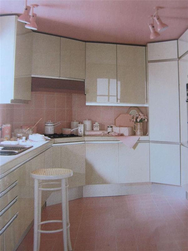 kuhinja z belimi omarami ter plaford in carrealge v komplementarni roza barvi