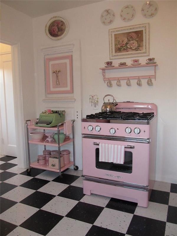 starinska kuhinja s črno -belimi ploščicami na tleh in pečico v bledo roza barvi