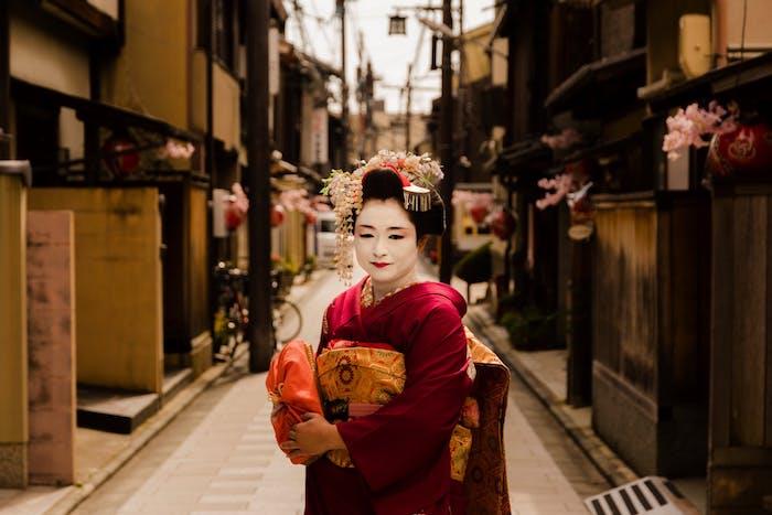 ženska v tradicionalnem japonskem kostumu na pisani in živahni estetski ulici