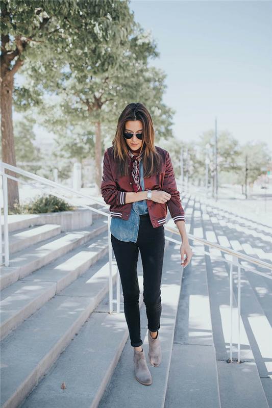 ženska v sivih čevljih tipa chelsea, jakni gollegienne in denim bluzi v ameriškem slogu