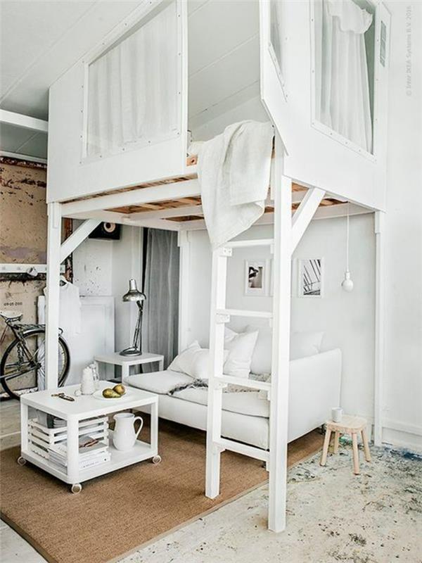 įrengti 15 m² ploto studiją, stalą, pagamintą iš baltai dažytų padėklų, lovos ir sofos zonų persidengimą apačioje, dviratį pastatytą prie įėjimo, baltas kopėčias, baltą sofą, pilką metalinį šviestuvą, litografijas ant sienos
