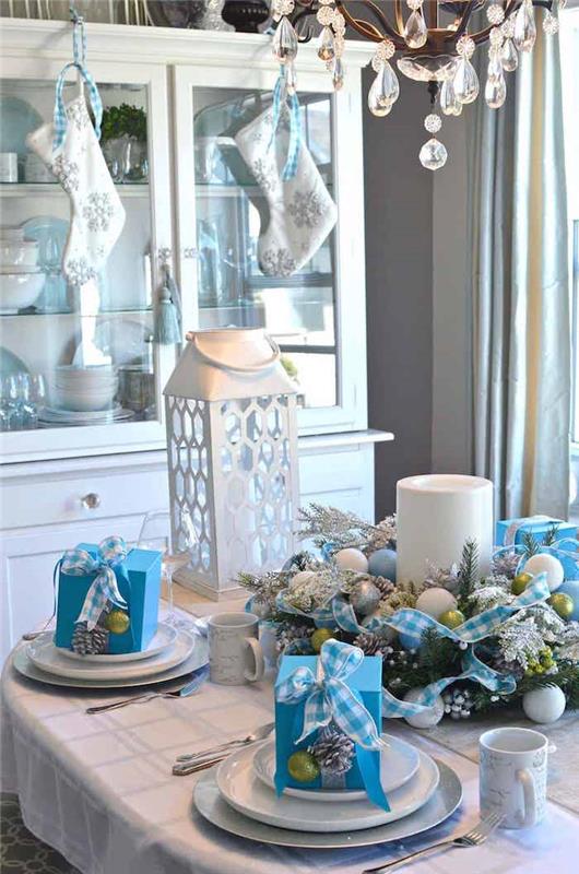 tabaklarda küçük hediyelerle mavi ve arjantinli bir Noel masa dekorasyonu fikri