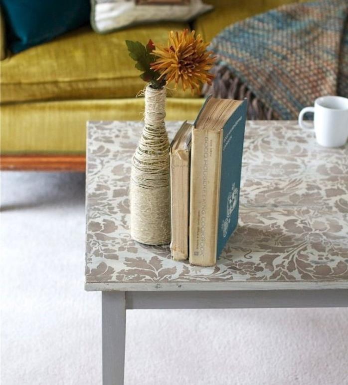 bir mobilyayı yenileyin, şablonla oluşturulmuş çiçek desenleriyle süslenmiş masa, kitaplar, iple süslenmiş şişe, oryantal tarzda kanepe