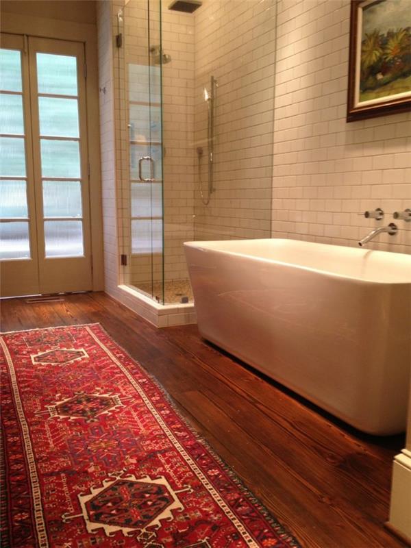 gražus vonios kambarys su baltomis plytelėmis ir tamsios medienos parketo grindimis