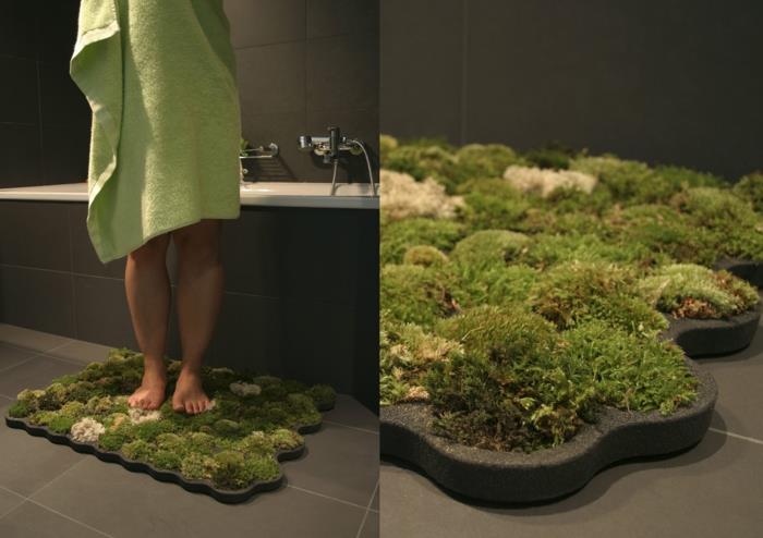 gražus vonios kambarys su pilkomis plytelėmis ir vonios kilimėliai, imituojantys veją