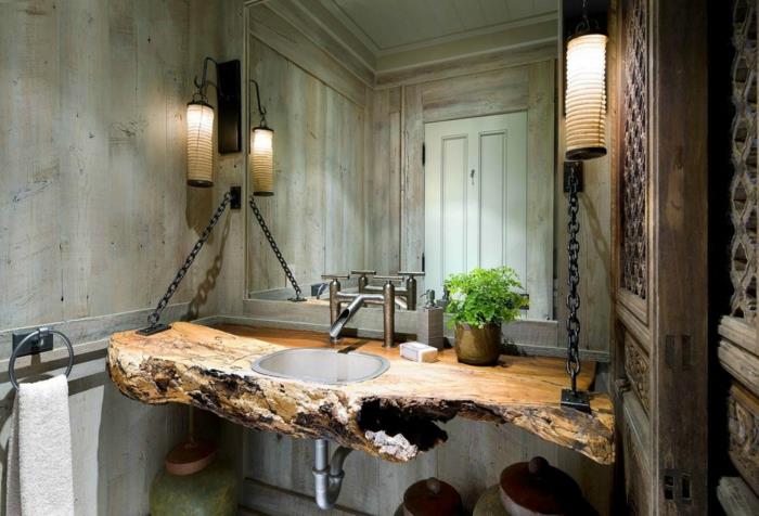 iç mekan bitkisi, iç mekan tırmanma tesisi, yeşil banyo, siyah metal iki yan zincirle tutulan düzensiz şekilli ağaç gövdesinden yapılmış lavabo dolabı