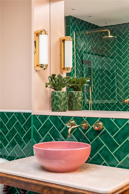 kopalnica z zelenimi ploščicami z zlatimi elementi in dopolnilnim rožnatim umivalnikom