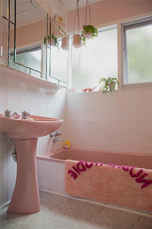 kopalnica v vintage stilu s kadjo in umivalnikom v stari barvi vrtnic in visečimi cvetličnimi lonci