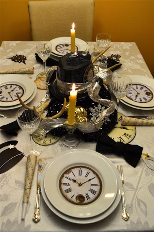 masanın ortasındaki tabak süslemeleri ve yanan mumlar üzerine çizilmiş bir saat ile yılbaşı için dekore edilmiş bir masa