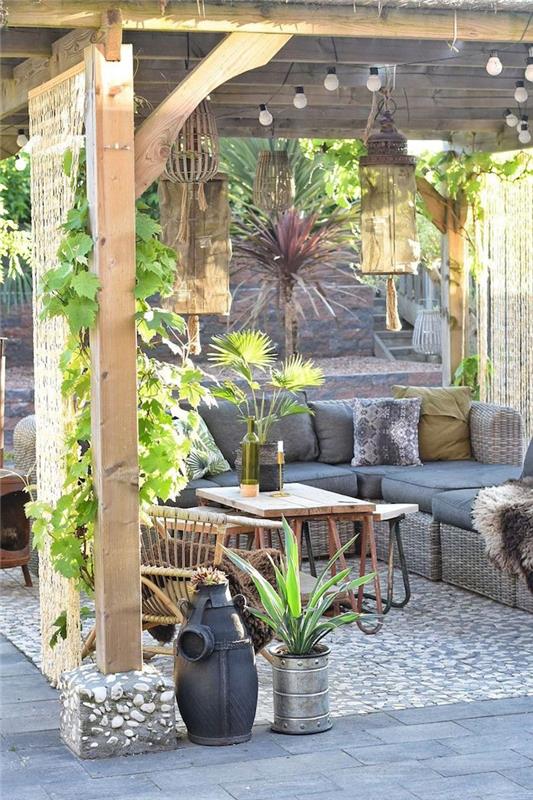 veranda su augaline vynmedžių siena ir rotango sofa