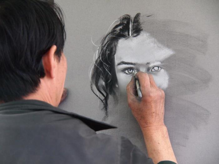Un uomo che disegna con i pastelli, disegno viso donna