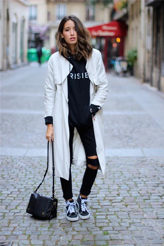 Ilgas baltas paltas, suplyšę juodi džinsai, juodas odinis krepšys, moteriškas gatvės drabužių stilius, hiphopo gatvės stiliaus suknelė
