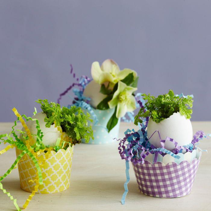 vaza iz jajčne lupine z majhnim šopkom cvetja v majhni papirnati košarici, napolnjeni s pisanimi papirnatimi konfeti