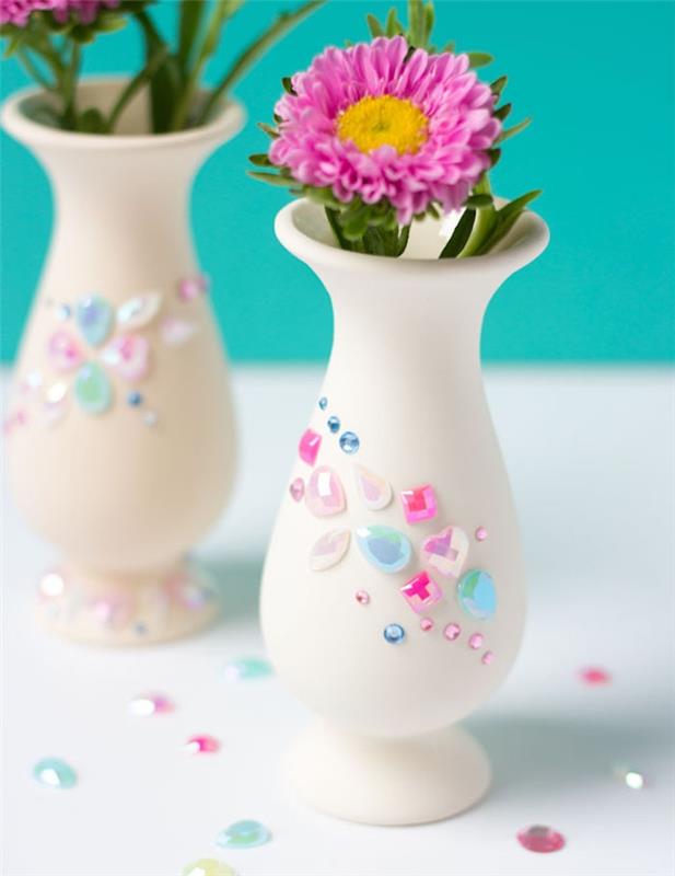 paprasta balta vaza su akmenimis ir spalvingais karoliukais bei gėlių šakelėmis, dovana Motinos dienai