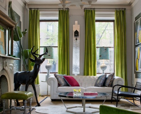 Amplia sala de estar con cortinas verdes.
