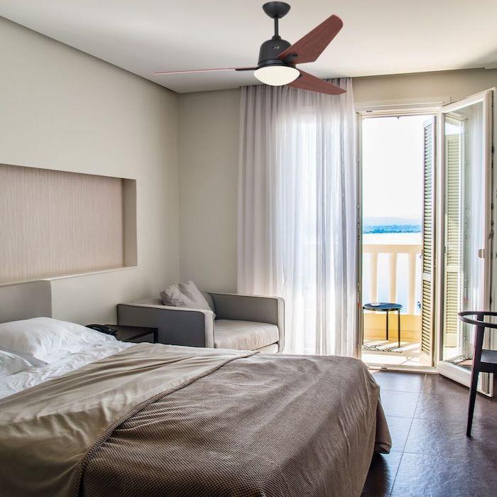 Modern yetişkin yatak odasında ışıklı sessiz tavan vantilatörü kahverengi karo zemin bej ve beyaz kahverengi çarşaf
