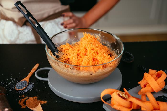 į kiaušinių ir miltų mišinį į dubenį įpilkite tarkuotų morkų, pagaminkite morkų pyragą be glitimo
