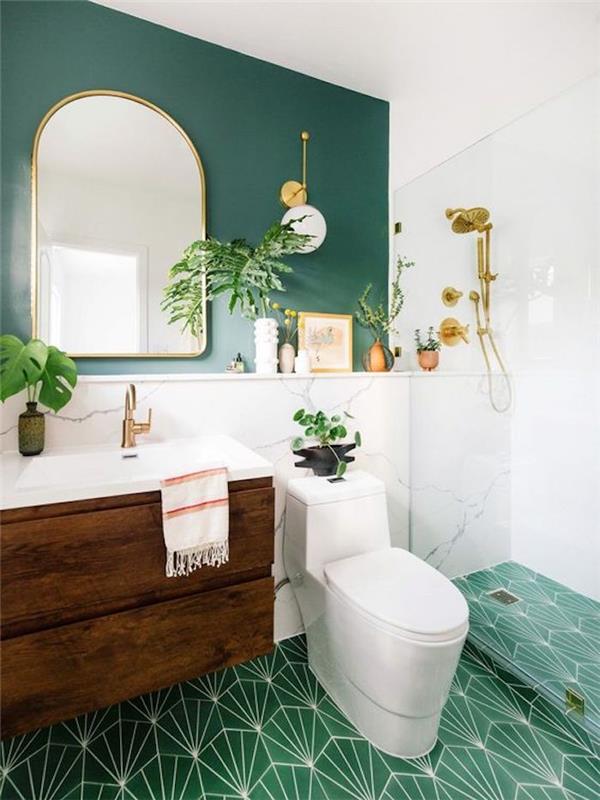 Vintage şık yeşil ve beyaz banyo, ayna duvar dekorasyonu ve yeşil bitkiler, cam bölmeli duş alanı