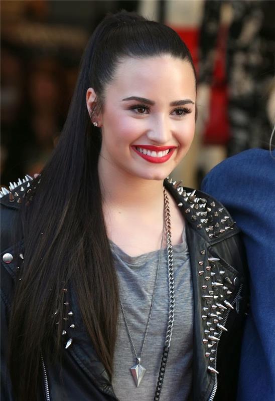 Demi Lovato, dolgi črni lasje, slavna pričeska, ženska v rock stilu s črno jakno iz umetnega usnja s čepi