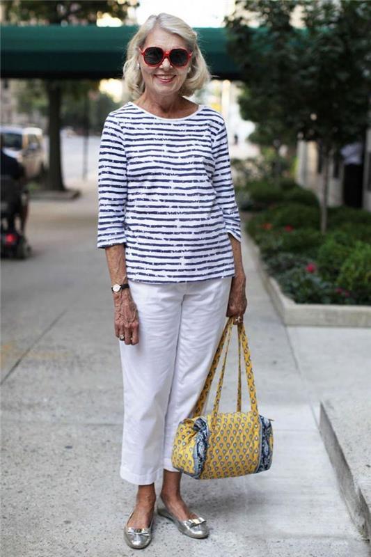50 yaşında bayan giyim trendy beyaz pantalpn ve beyaz ve siyah bluz güneş gözlüğü trendy sarı çanta