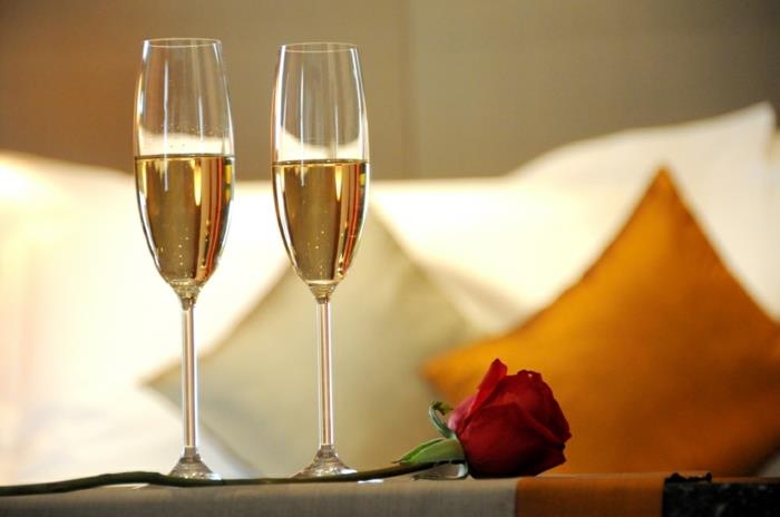 Şampanya seti, kırmızı gül, otel odası, yatak ve minderler, romantik sevgililer günü için fotoğraf iç