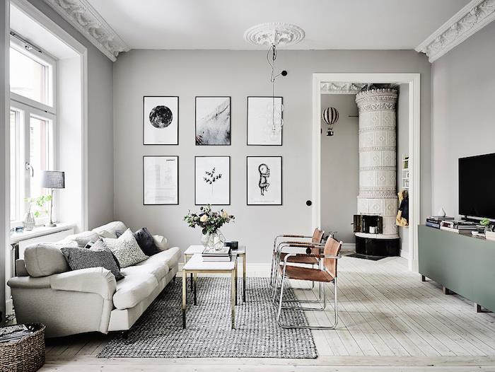 svetainės dažų spalvos, šviesiai pilkos sienos, šviesiai smėlio spalvos laminato grindys, beveik balta sofa ir rudos kėdės, pilkas dėmėtas kilimas