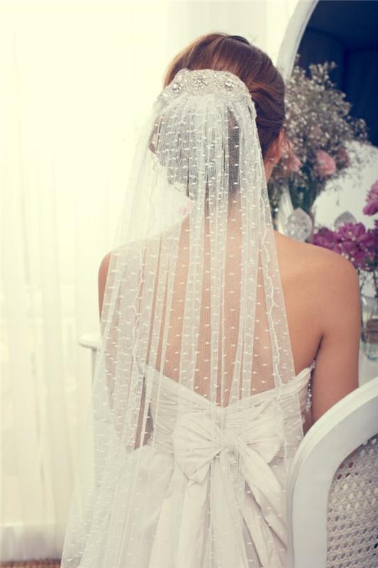 elegantišką taškuotą jaunikio šydą ir žemą vestuvių bandelę