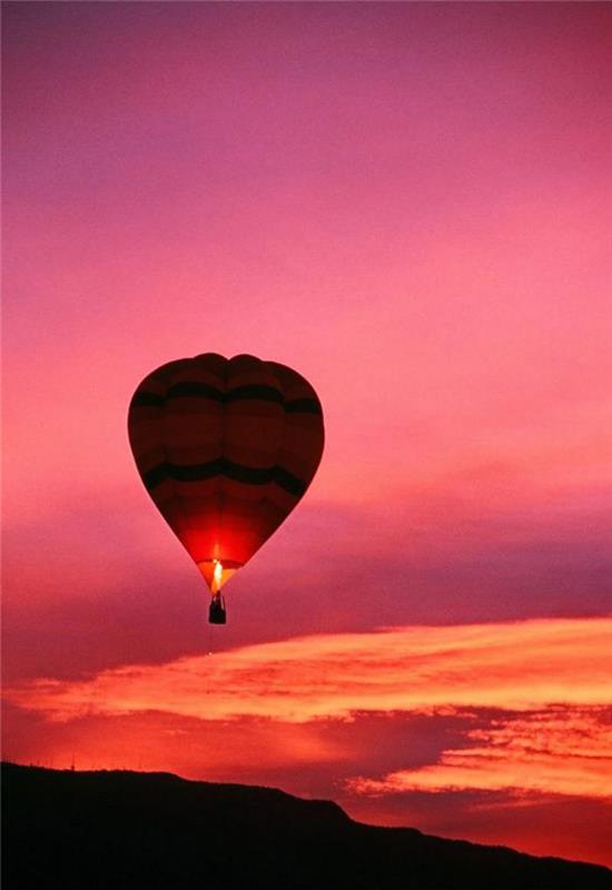 gökyüzünde günbatımında sıcak hava balonuna binmek