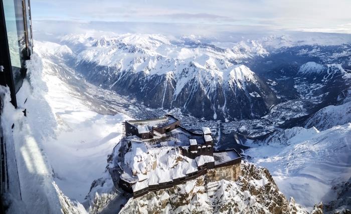 Bir hake üzerinde karlı bir kaleye teleferik manzarasının fotoğrafı, dağların kuşbakışı manzaralı kış manzarası