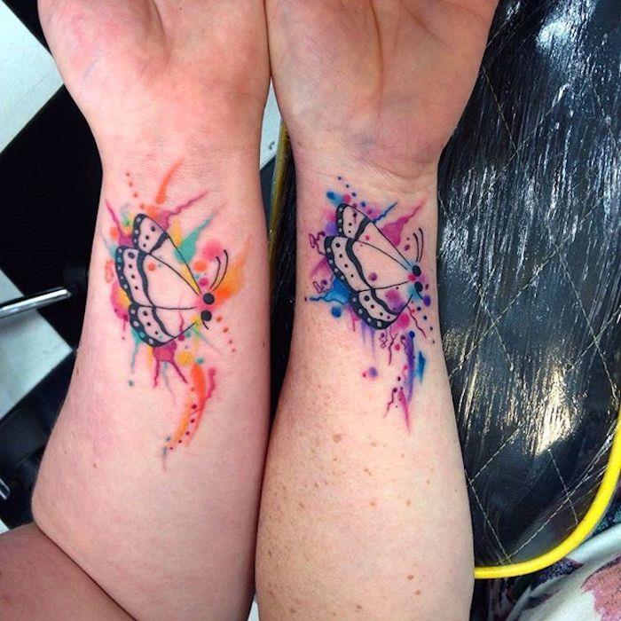 Tatuaggi uomo sul polso della mano con il disegno di due farfalle colorate