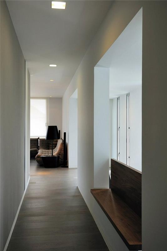 beli hodnik z okni na eni strani, minimalistična lesena klop, laminatna tla in kvadratne stropne svetilke, ideje za dekor hodnika, pohištvo v ozadju